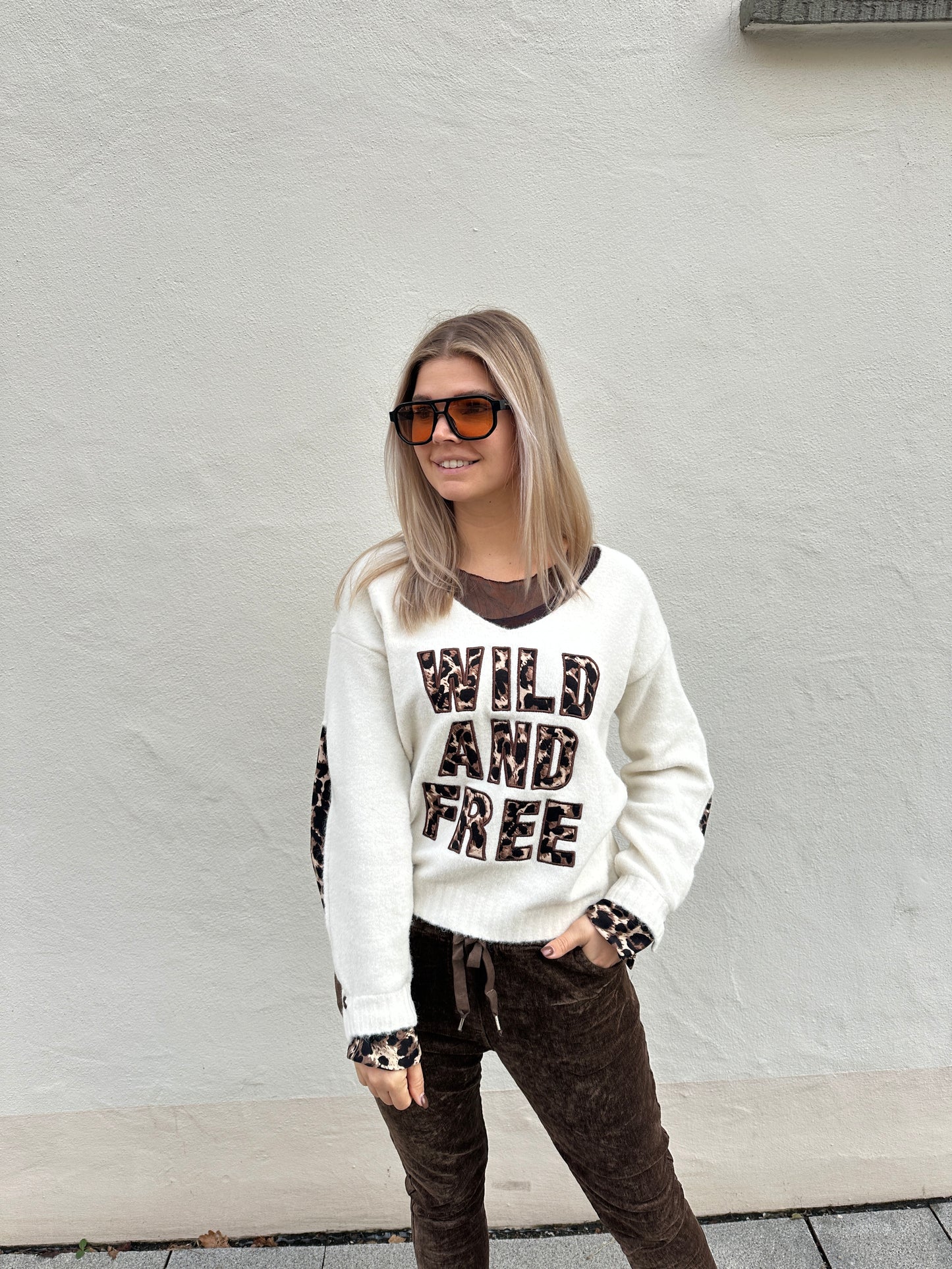 pullover in wollweiß mit v-auschnitt und aufschrift (wild and free)