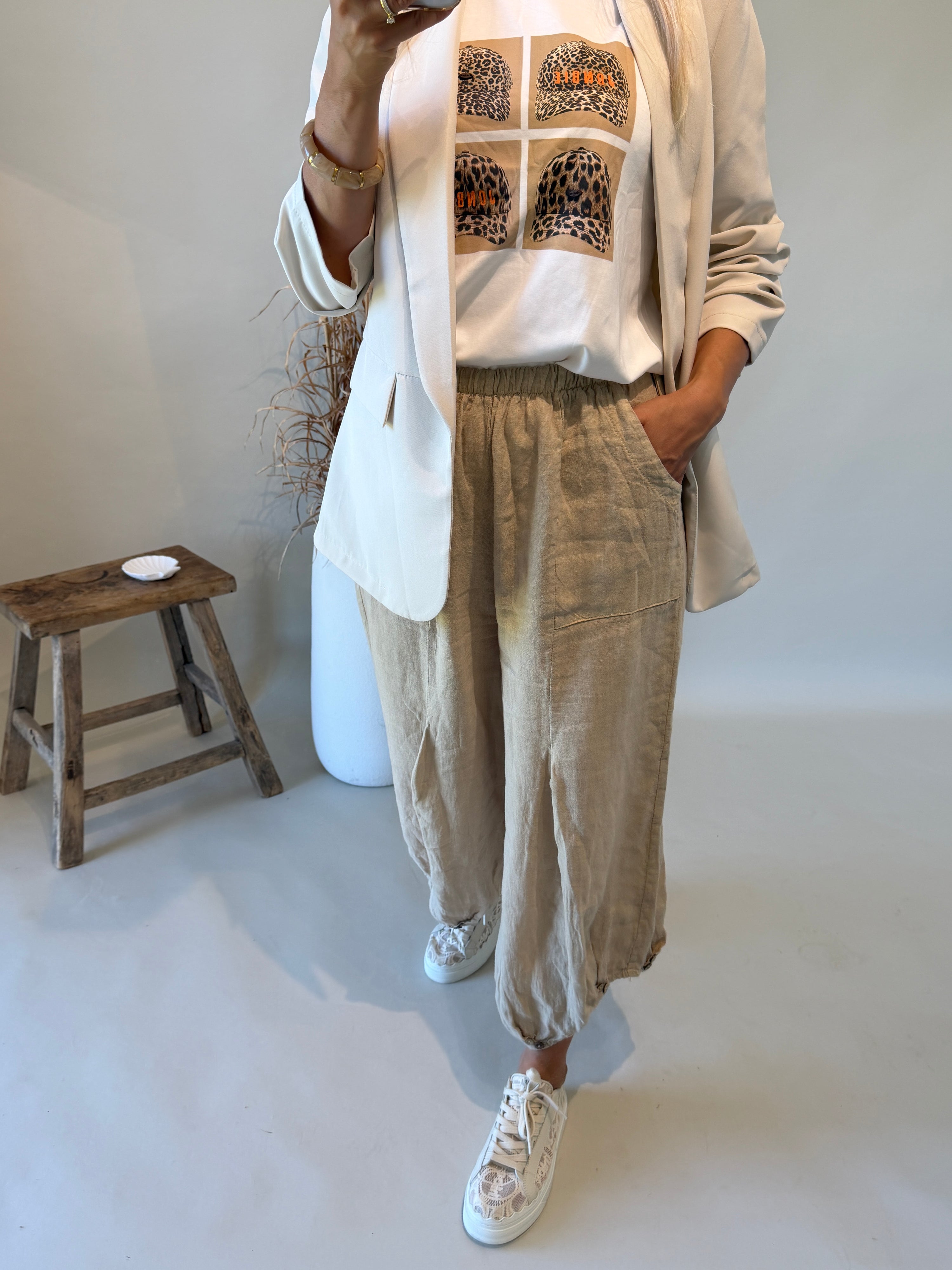 Hose in Beige mit großen Taschen und Knöpfen am Bein