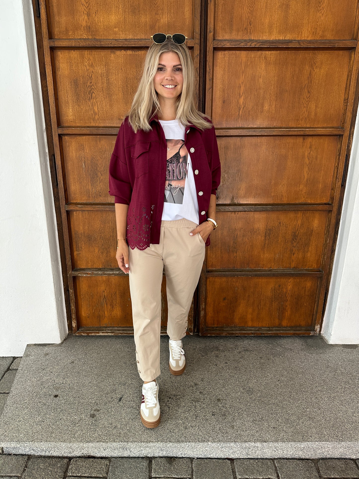 hose in beige mit goldenen knöpfen am bein