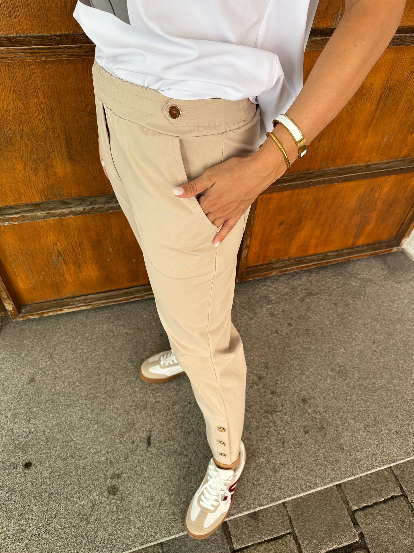 hose in beige mit goldenen knöpfen am bein