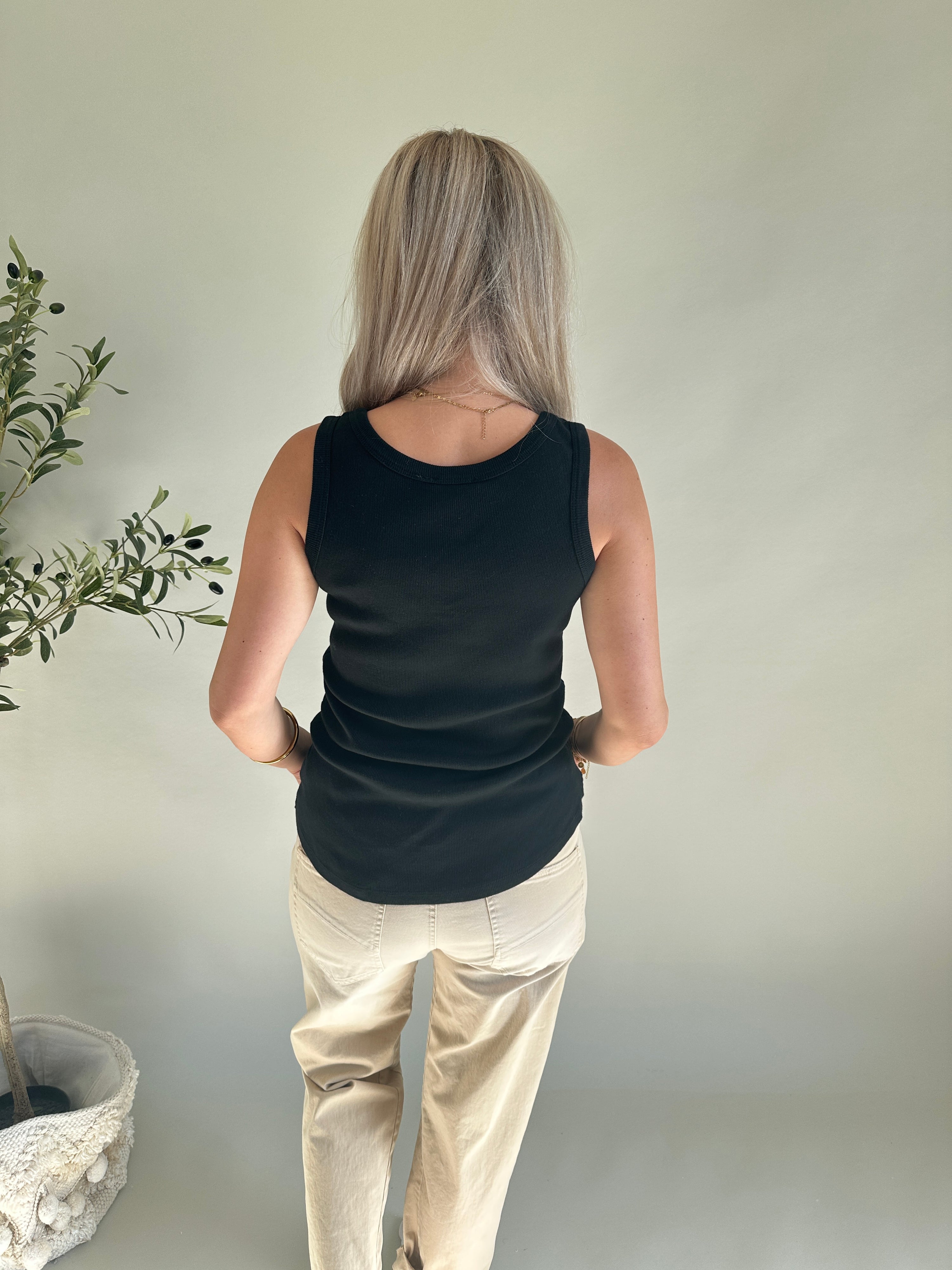 Top in Schwarz mit Spitze unten am Bund