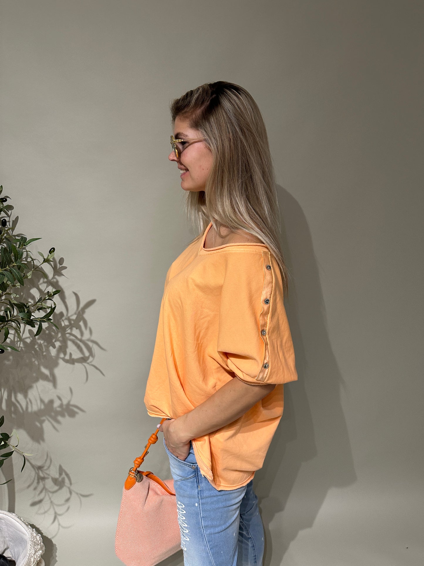 shirt in orange mit knöpfen am ärmel