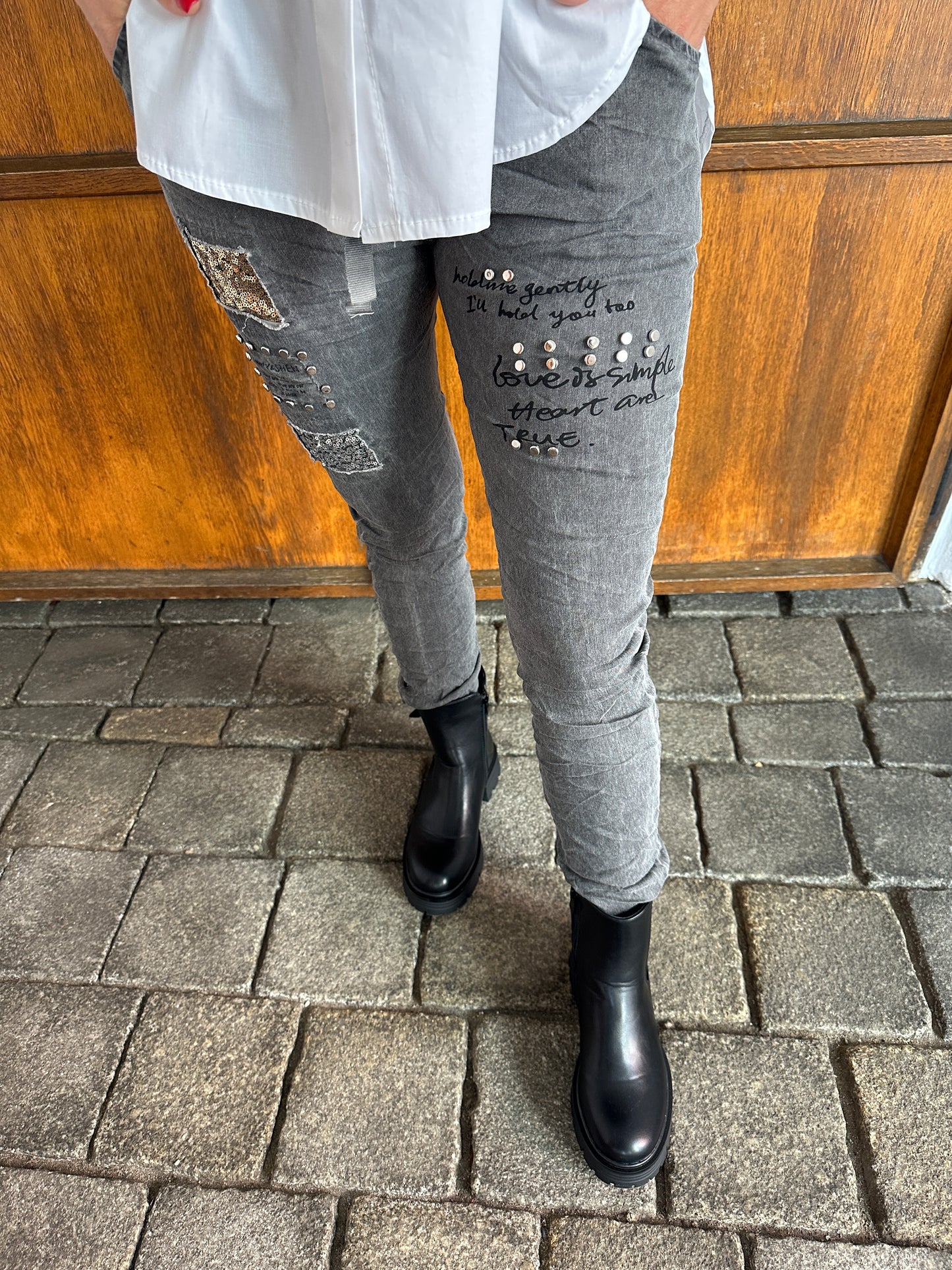 hose in grau mit aufschrift und glitzer am bein