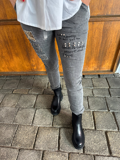 Hose in Grau mit Aufschrift und Glitzer am Bein