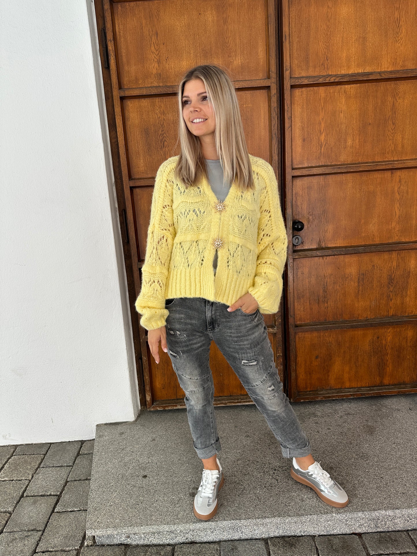 strickjacke in zitronengelb  mit goldenen spangen