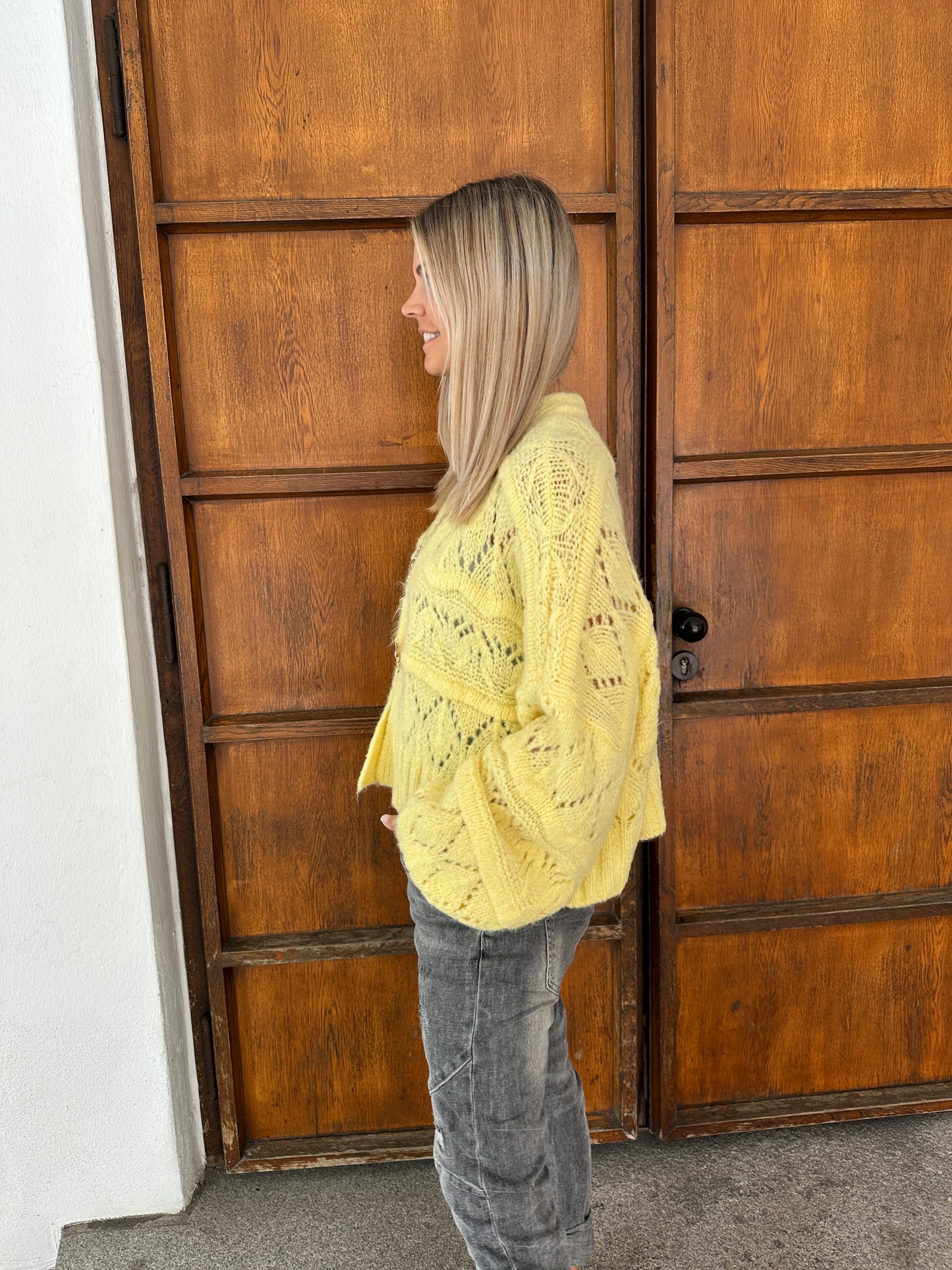 strickjacke in zitronengelb  mit goldenen spangen