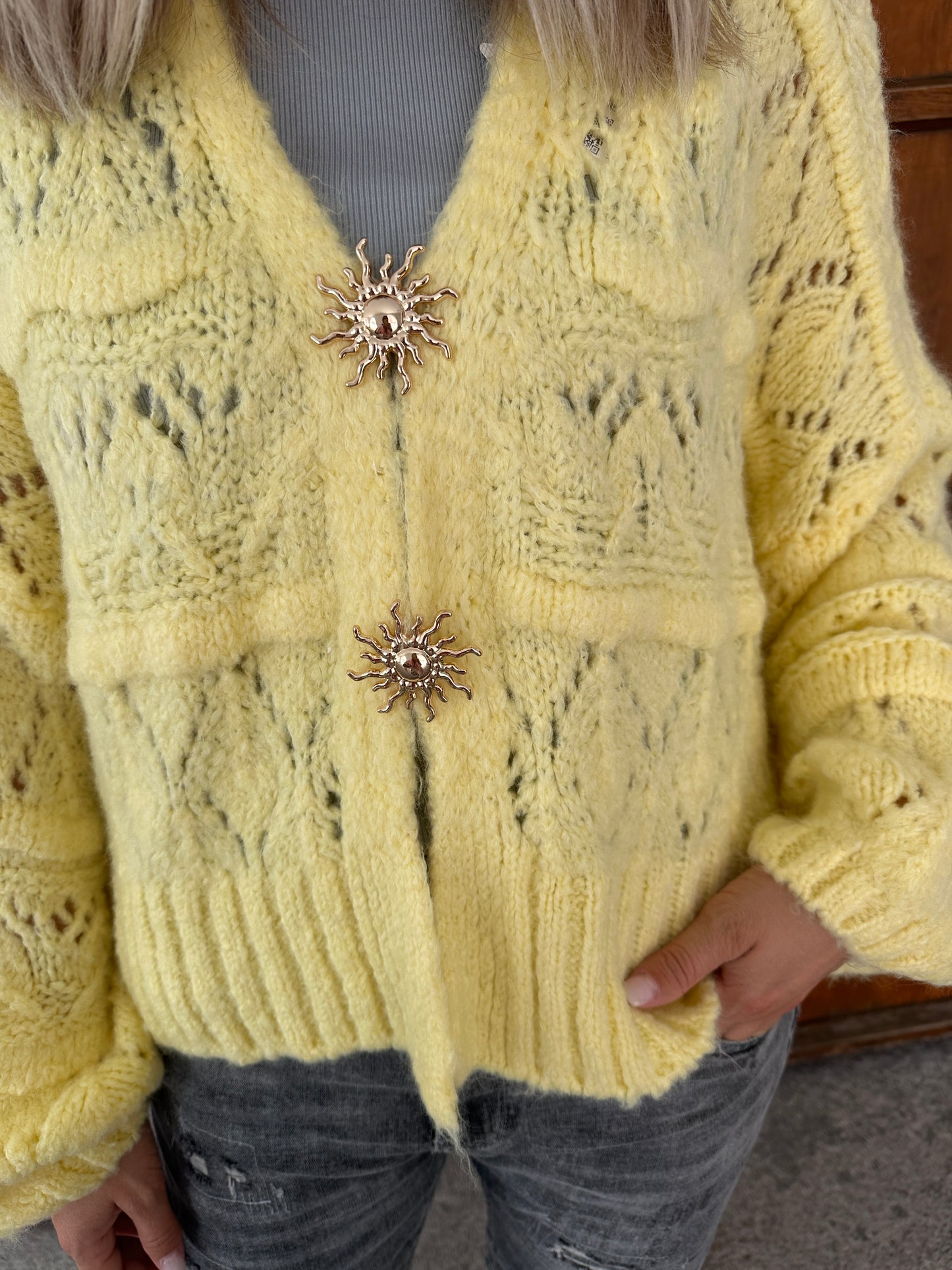 strickjacke in zitronengelb  mit goldenen spangen